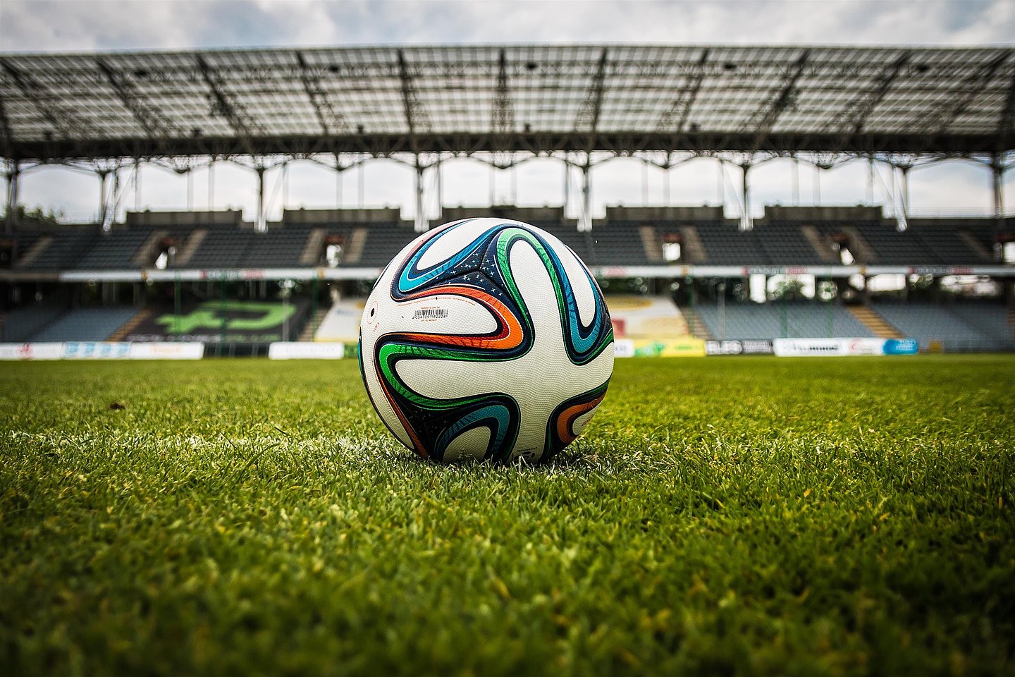 Nahaufnahme eines Fußballs am Anstoßpunkt auf einer Rasenfläche in einem Stadion